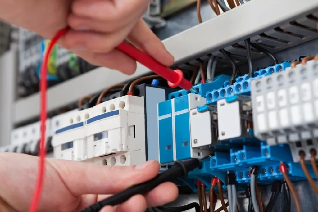 A skilled electrician is fixing a broken circuit breaker panel during an emergency.